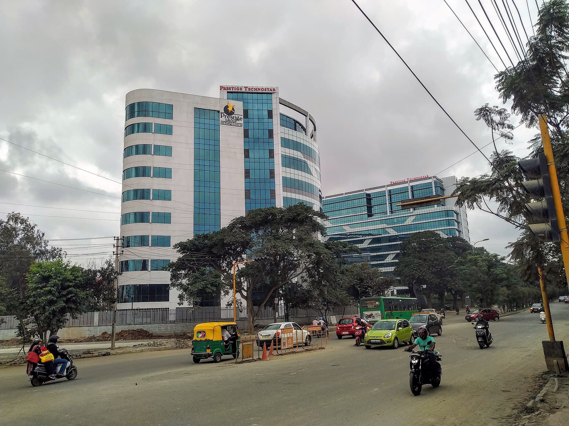 Prestige Technostar tech park in Kundalahalli, Bengaluru, with auto rickshaws and traffic on the road outside